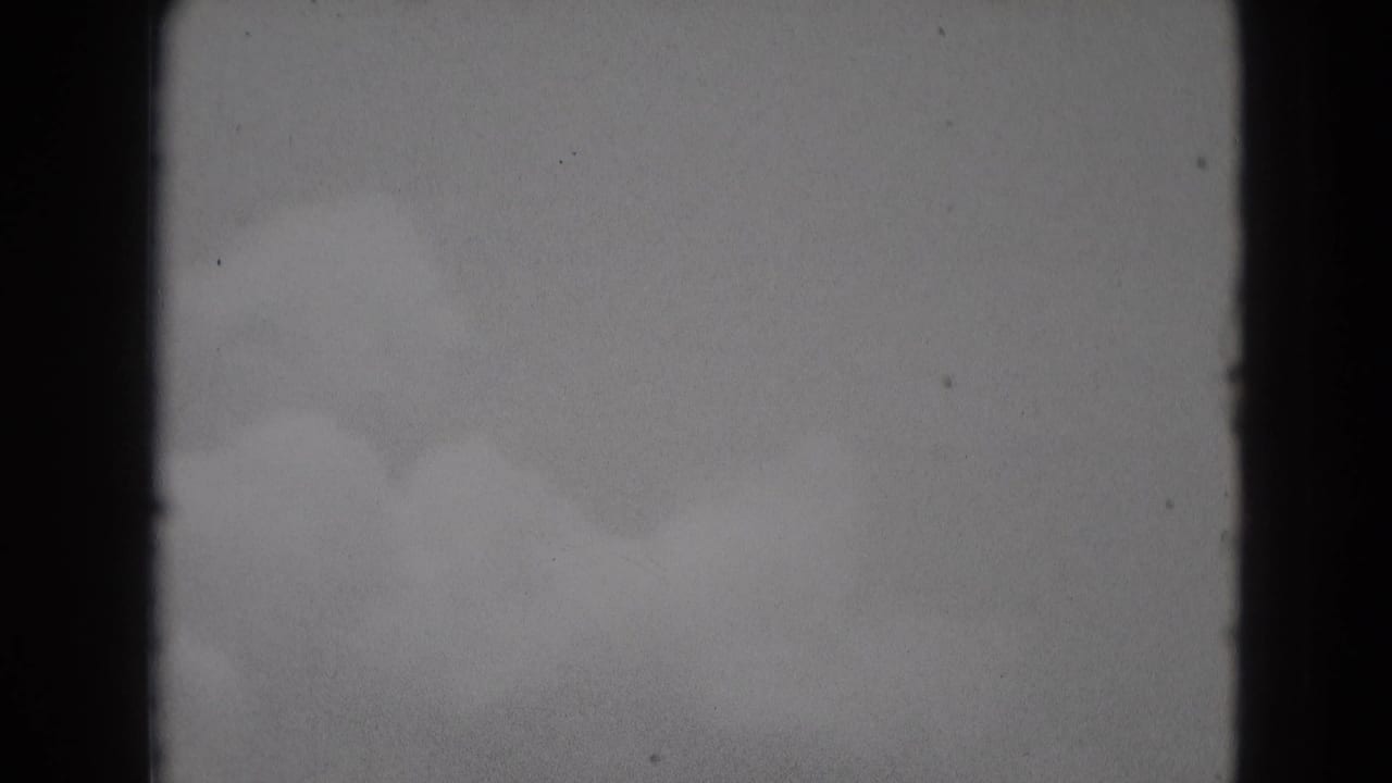 Cloudy gray sky framed by dark vertical film edges.