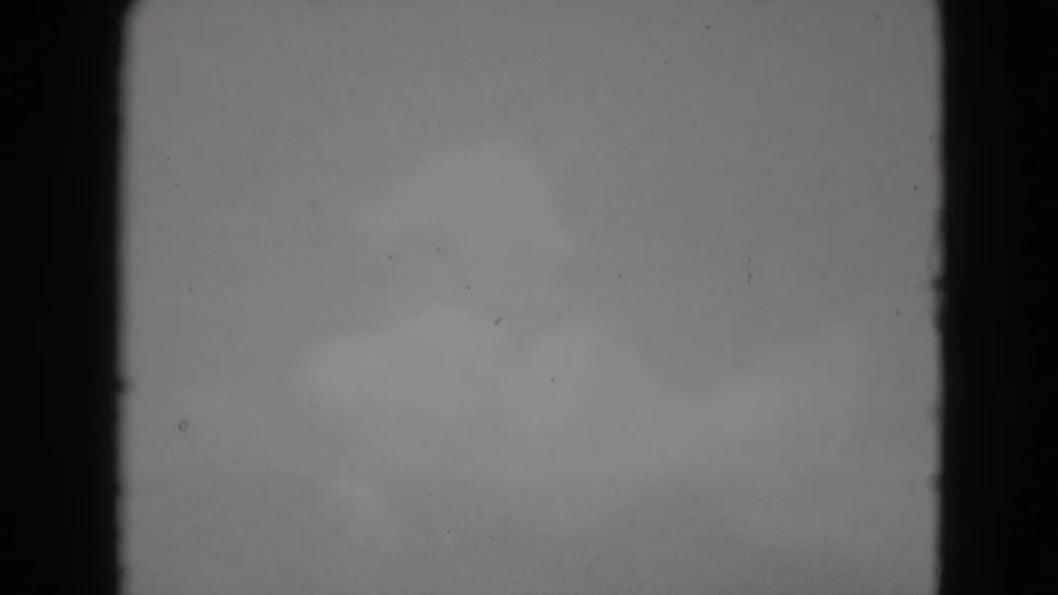 1975 Middletown home-movie frame showing a brighter patch of cloudy sky with soft texture and visible film grain.