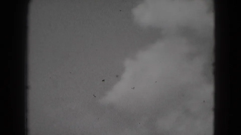 1975 Middletown, Pennsylvania 8mm frame showing a cloudy pale sky, soft focus, dark edge borders, grain, and small dust specks.