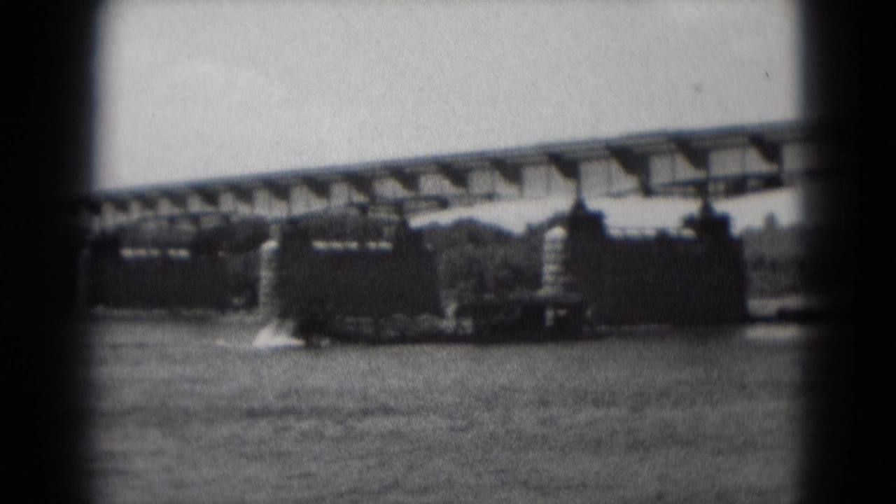 Soft black-and-white 8mm frame of a sternwheeler-style boat on the river beneath a bridge in Middletown, Pennsylvania.