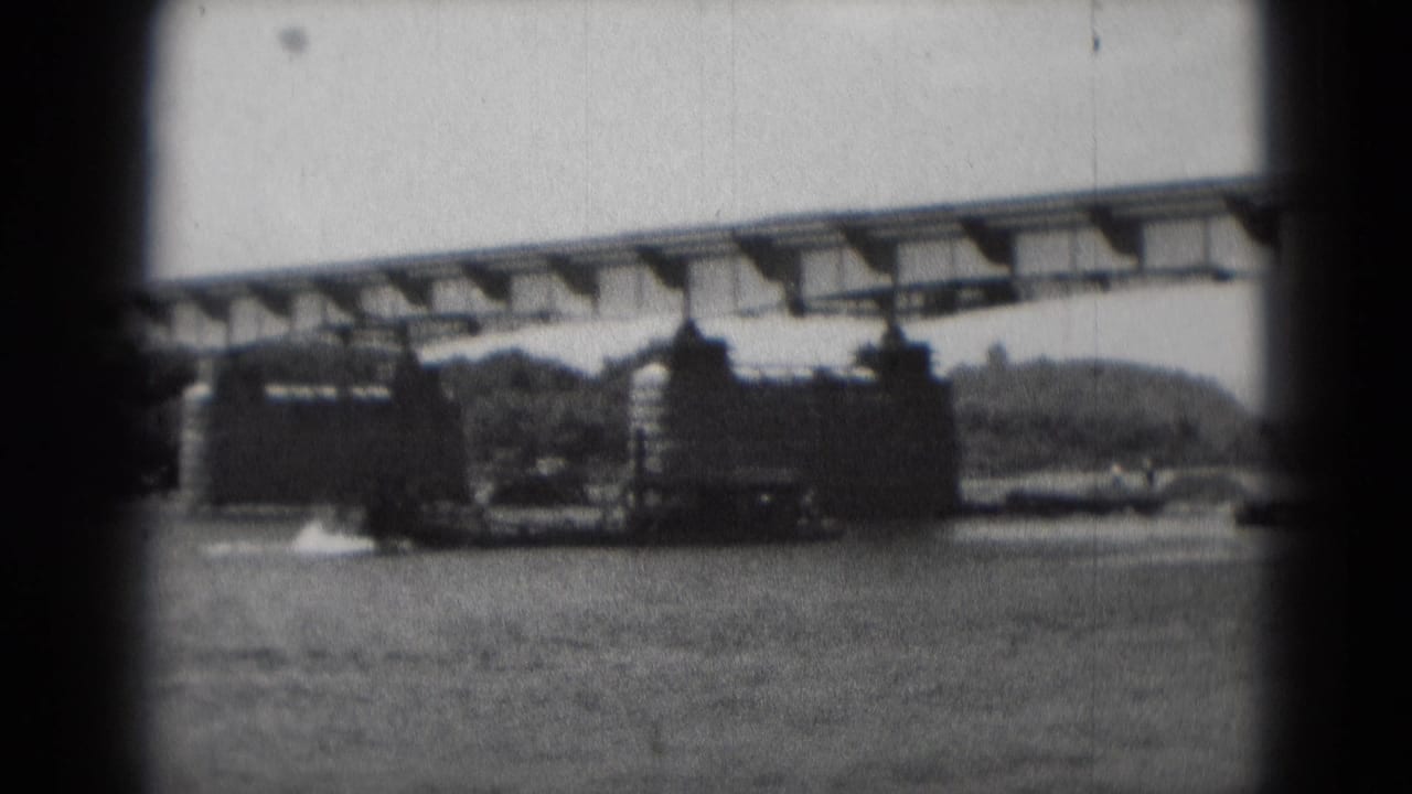 1975 Middletown, Pennsylvania home-movie frame showing bridge construction over water with piers, steel work, and crane activity.