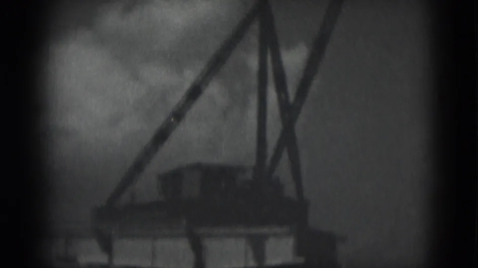 1975 Middletown, Pennsylvania frame with a crane-like A-frame structure rising above low buildings in a grainy home-movie view.