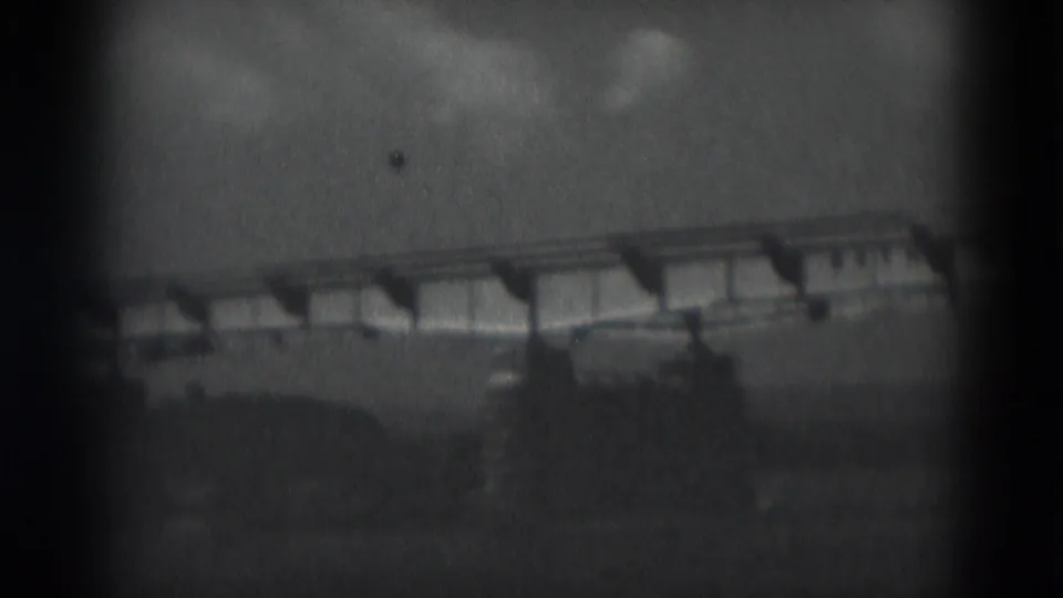 1975 Middletown, Pennsylvania 8mm frame showing a long bridge or elevated roadway and low structures under cloud cover.