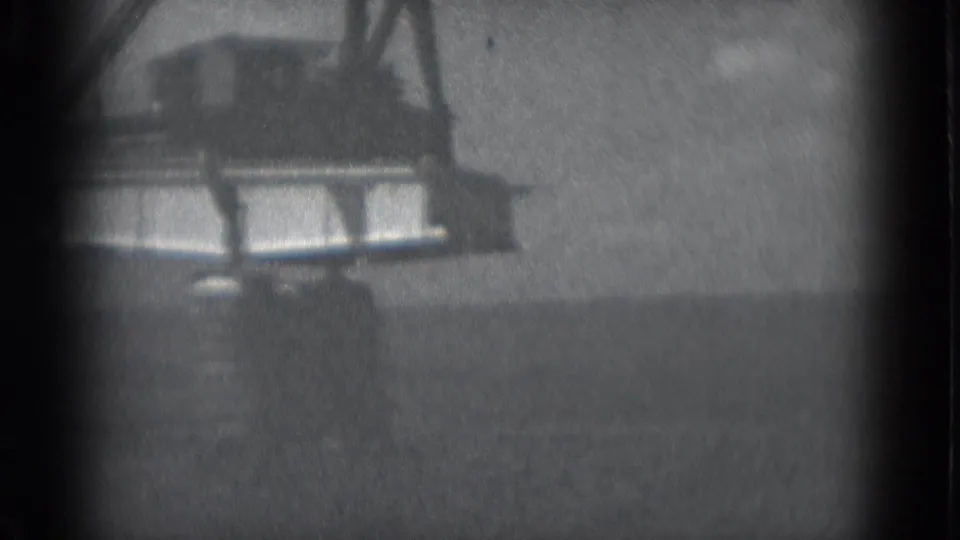 1975 Middletown, Pennsylvania 8mm frame showing a crane boom over a suspended bridge section in soft black-and-white focus.
