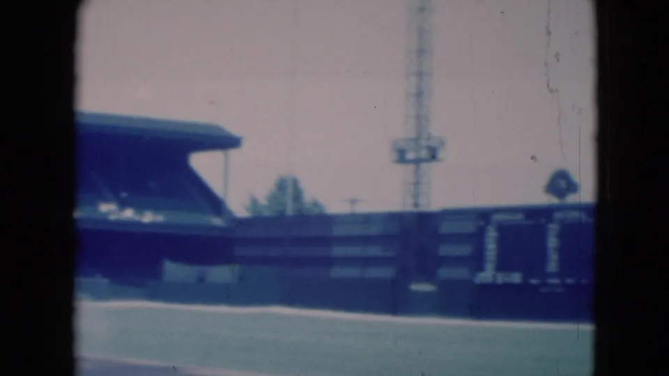 Middletown, Pennsylvania ballpark view with the outfield wall, scoreboard area, covered seating, and light tower visible on 8mm film.