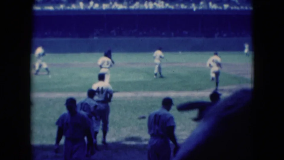 1975 Middletown, Pennsylvania 8mm frame showing baseball players running on the field with a crowd in the background.