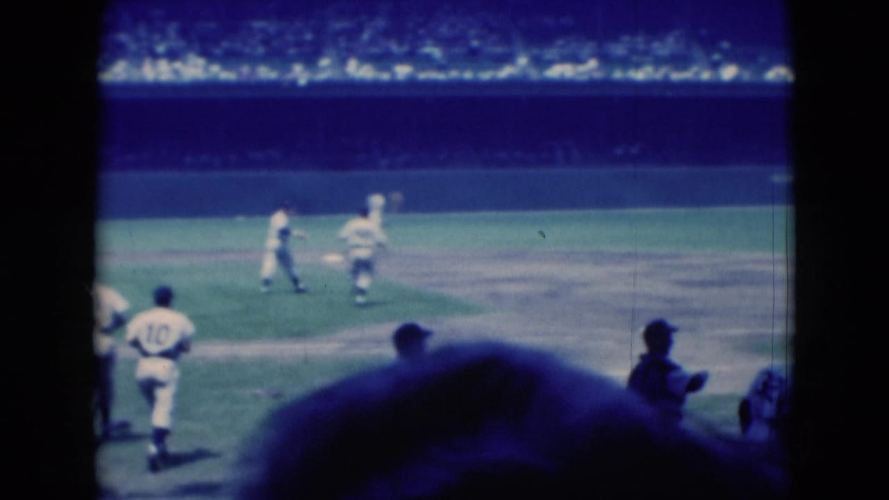 Spectator-shot 1975 baseball footage in Middletown, Pennsylvania, with players running near the infield and crowd seating behind them.