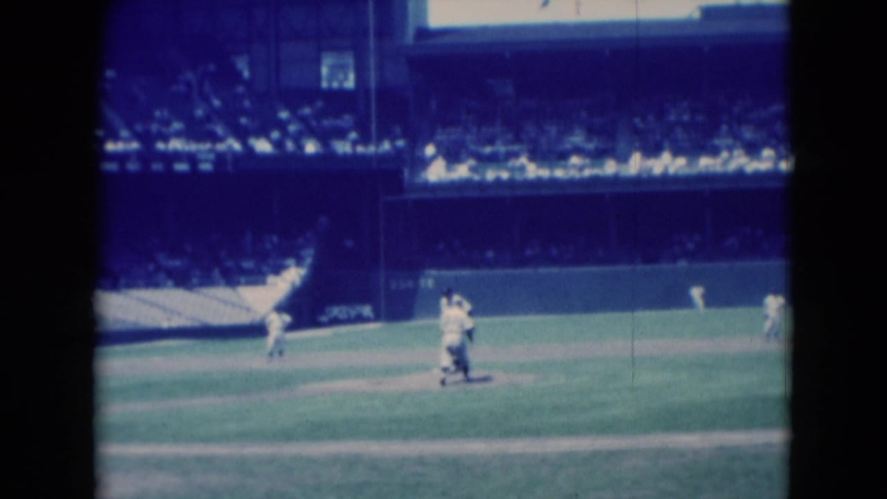 Two baseball players near the infield with a large stadium crowd behind them.