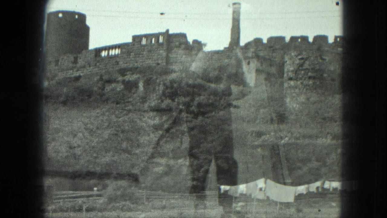 The listed Milwaukee 1975 frame holds on ruined masonry, a cylindrical tower, a chimney, hillside brush, and laundry in the lower foreground.