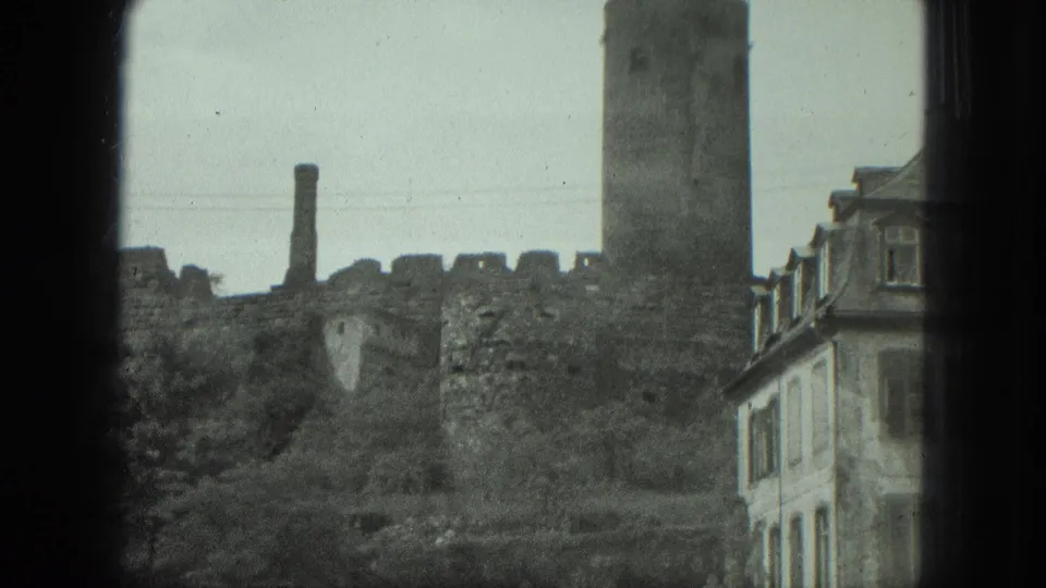 The final 1975 frame listed as Milwaukee shows ruined masonry and a chimney, with a tall building and row of windows at right.