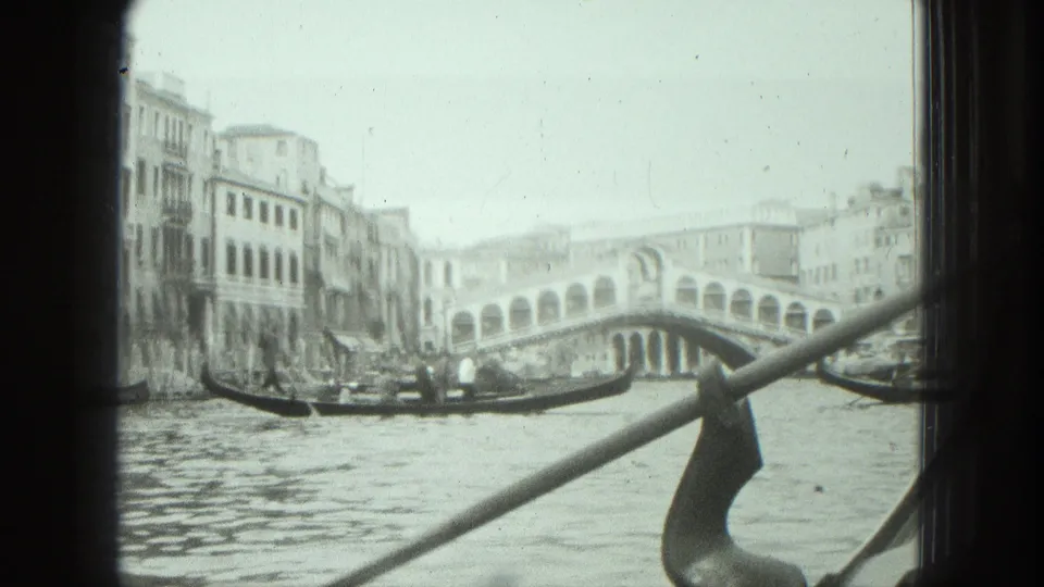 1975 Venice 8mm view from a gondola toward the Rialto Bridge, with another gondola crossing the canal.