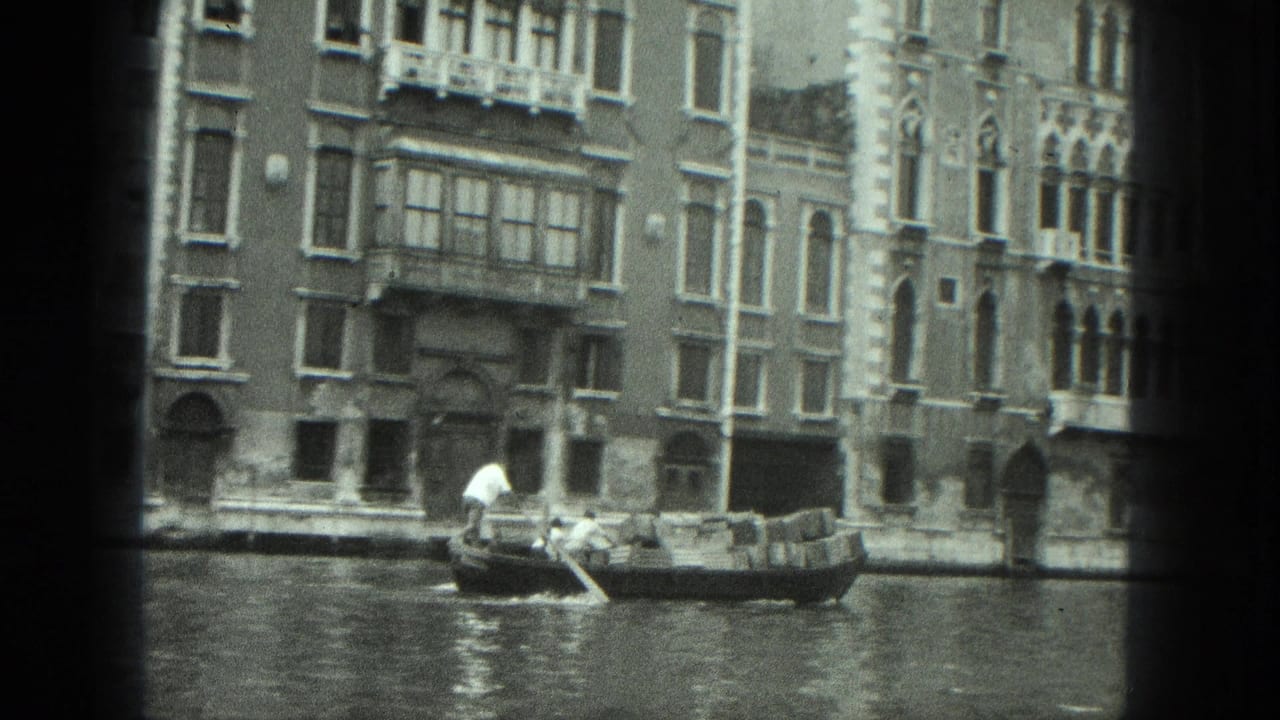 1975 Venice home-movie frame showing a gondola and gondolier on a canal before ornate waterfront architecture.