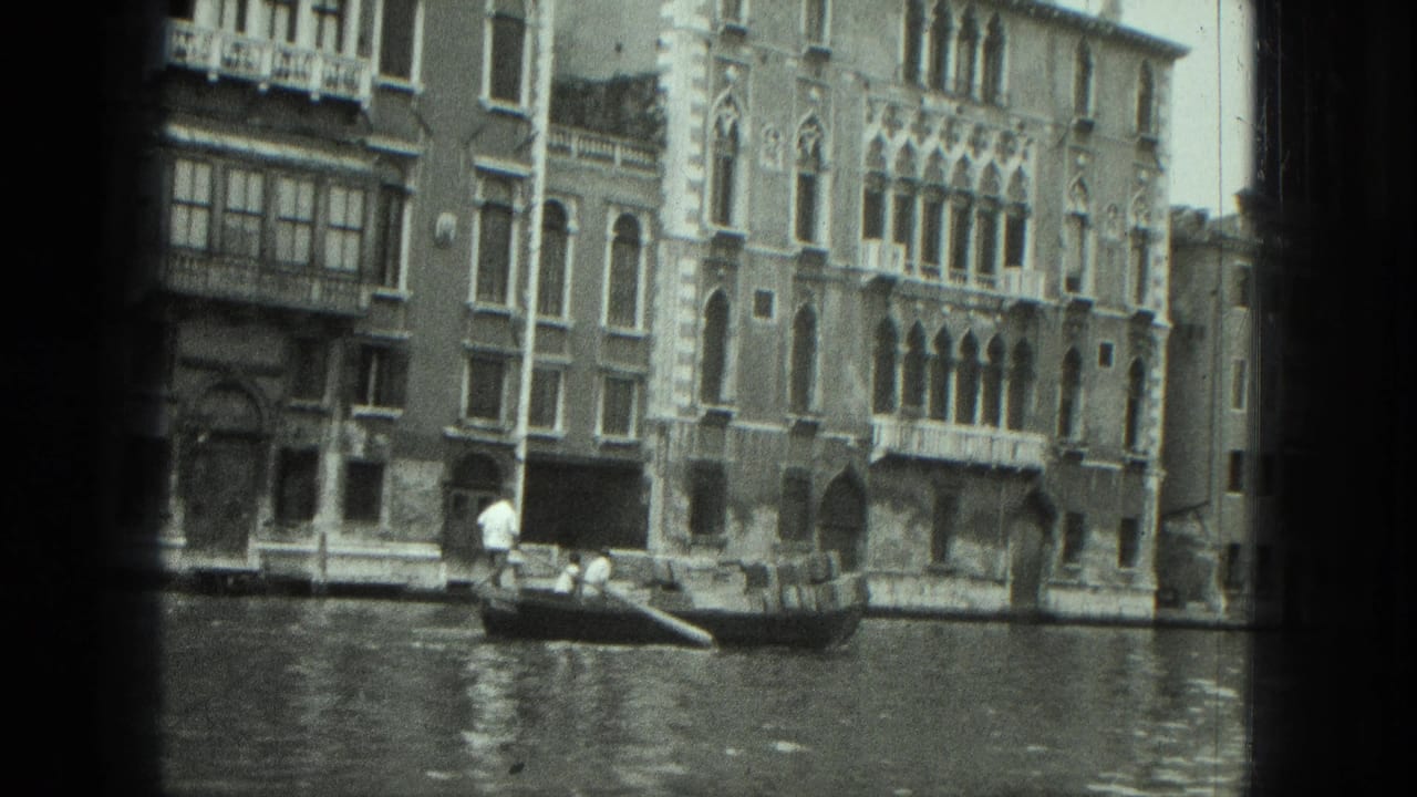Gondola and gondolier on canal water with decorative buildings in the background.