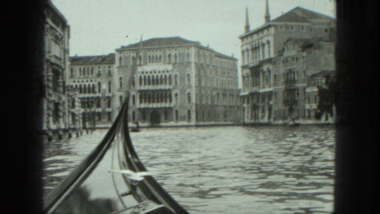 1975 8mm Venice canal view from a gondola, with rippling water and historic arched facades ahead.