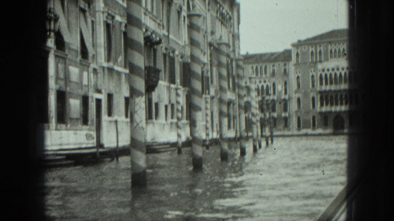 Canal view from a boat with Venetian buildings, striped poles, and rippled water.