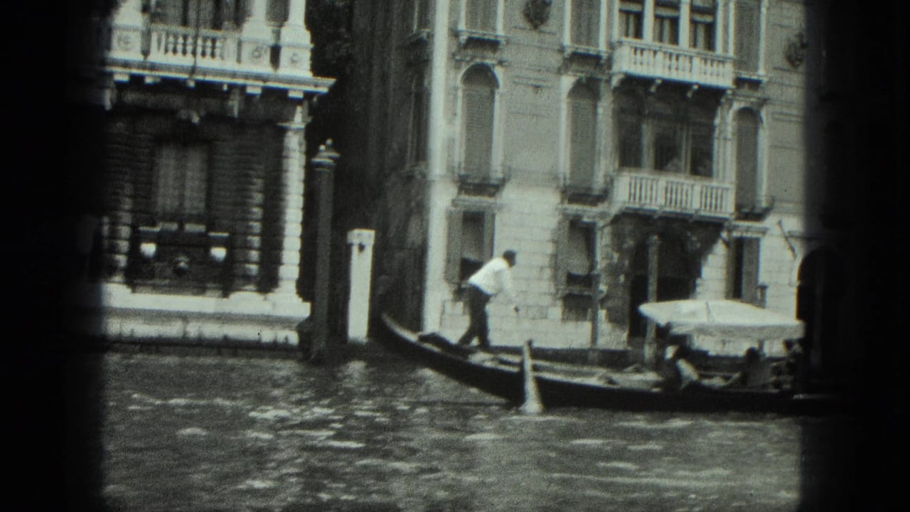 Gondolier and passenger move past a dark palazzo facade on the canal.