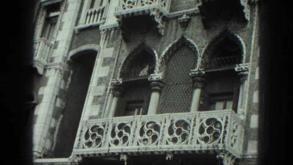 Close 1975 Venice view of an ornate Gothic-style balcony with carved railing, columns, and arched window openings.