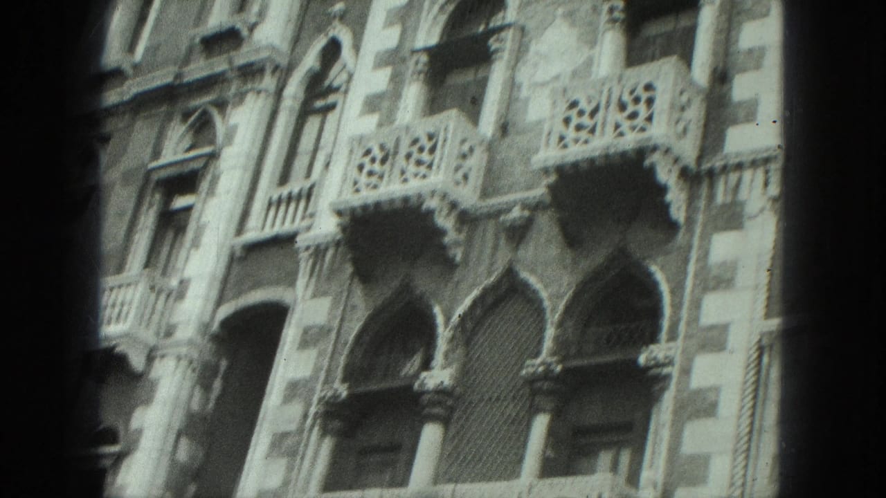 1975 Venice home-movie frame showing an ornate canal-side facade with arched windows, columns, and decorative balconies.