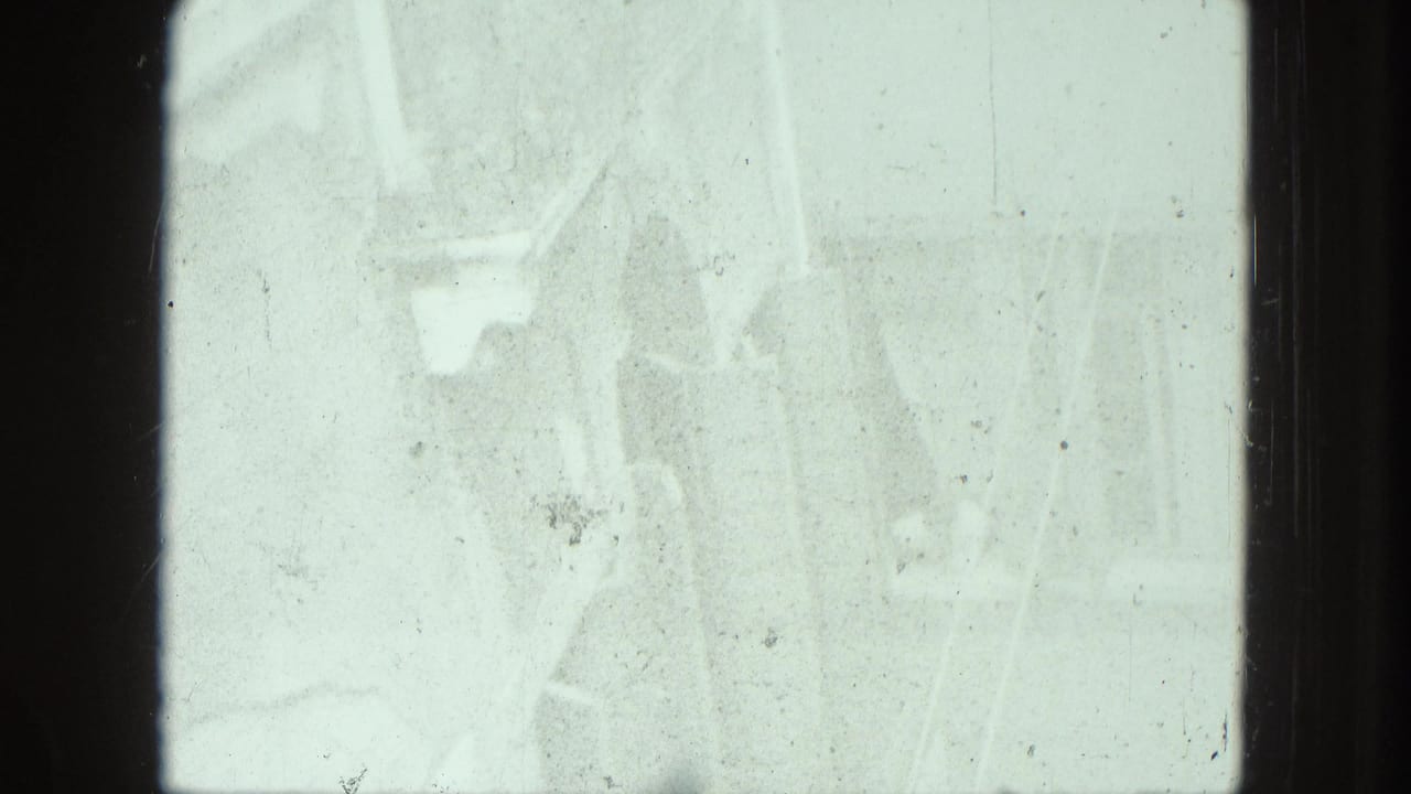 Overexposed frame with faint architectural shapes and film scratches.