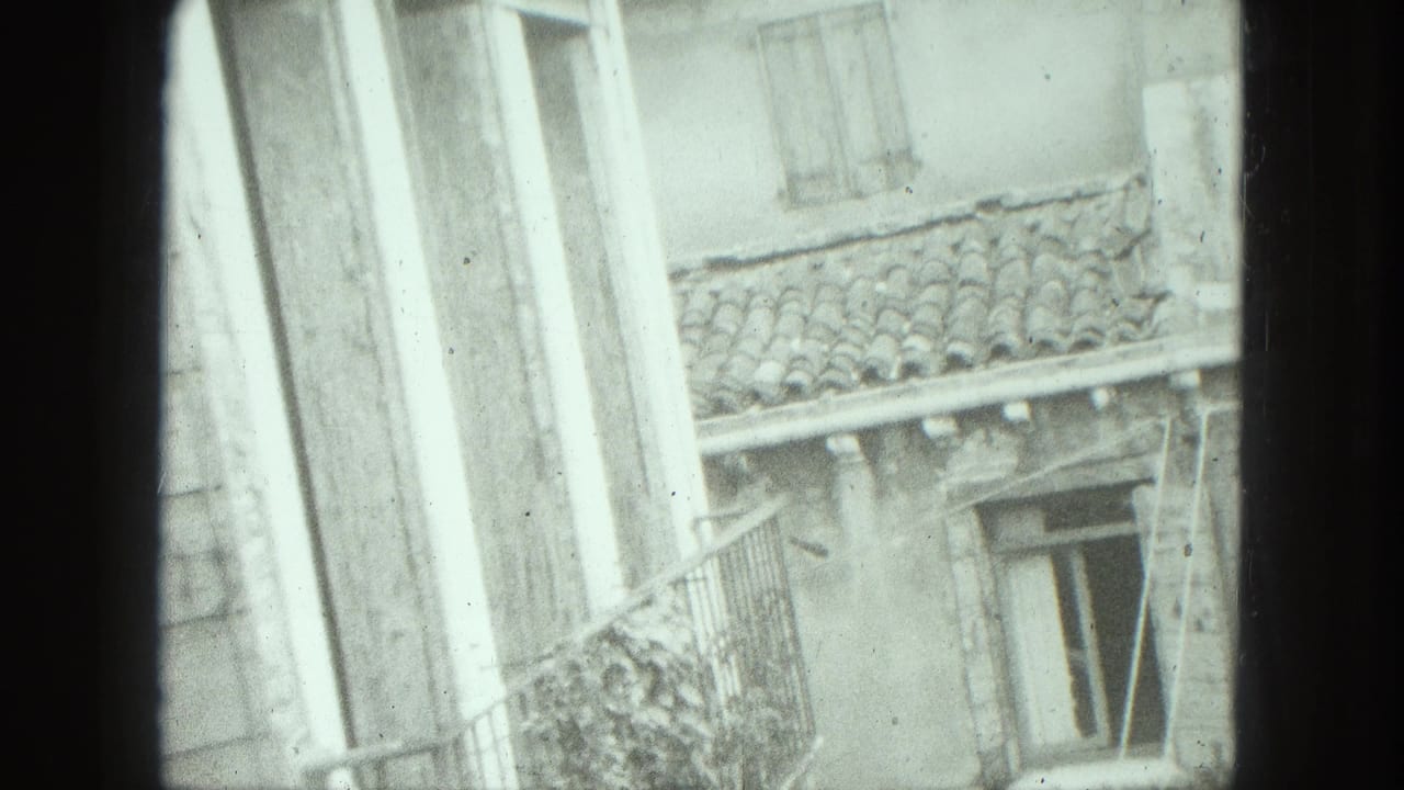 1975 Venice home-movie frame showing weathered exterior walls, shuttered windows, a balcony rail, and clay roof tiles.