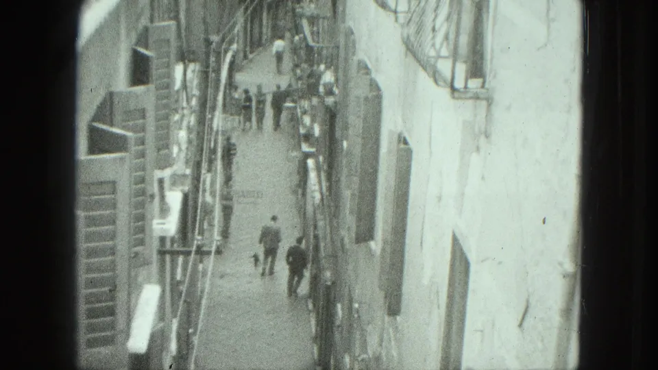 1975 Venice home-movie frame looking down on narrow pedestrian streets between close building walls.