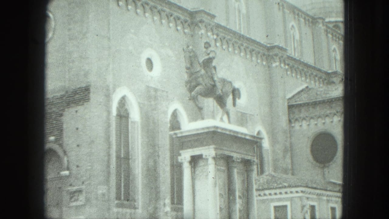 Equestrian statue on a pedestal in front of arched windows and stone facade.