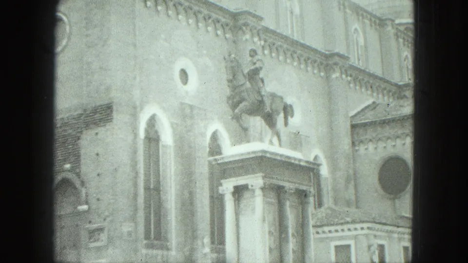 1975 Venice frame showing the equestrian monument and adjacent historic facade within visible 8mm frame borders.