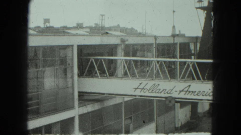 1975 Venice port footage showing a mobile gangway marked Holland-America Line near a glass-panel terminal facade.