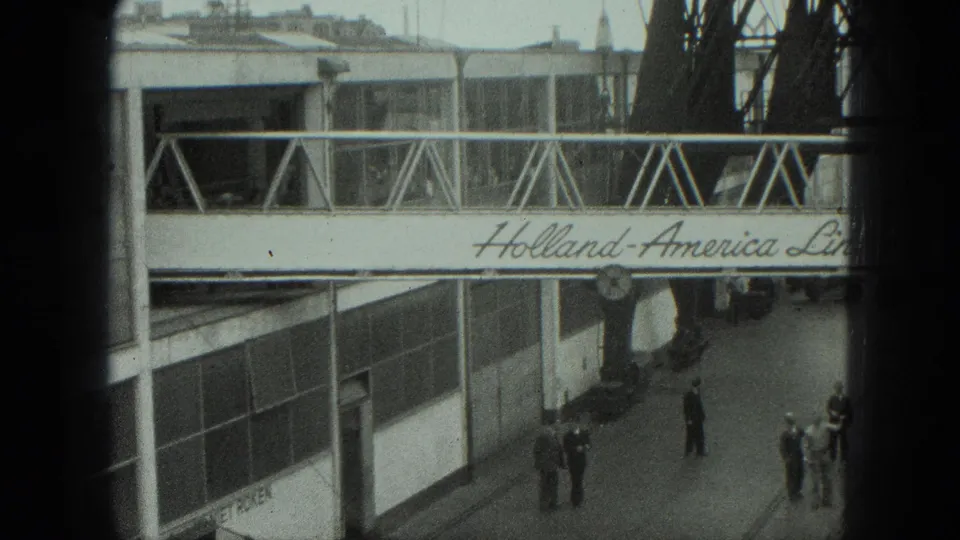 1975 Venice port scene with Holland-America Line gangway, terminal glass, and uniformed people gathered below.