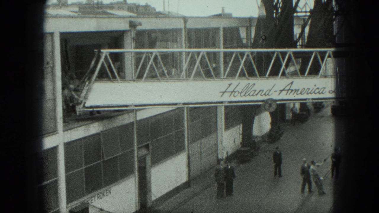 Workers and bystanders near a Holland-America Line gangway at a terminal dock.