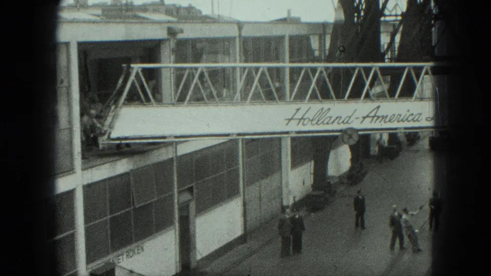 1975 Venice terminal view with workers below and a Holland-America Line gangway spanning the dock area.