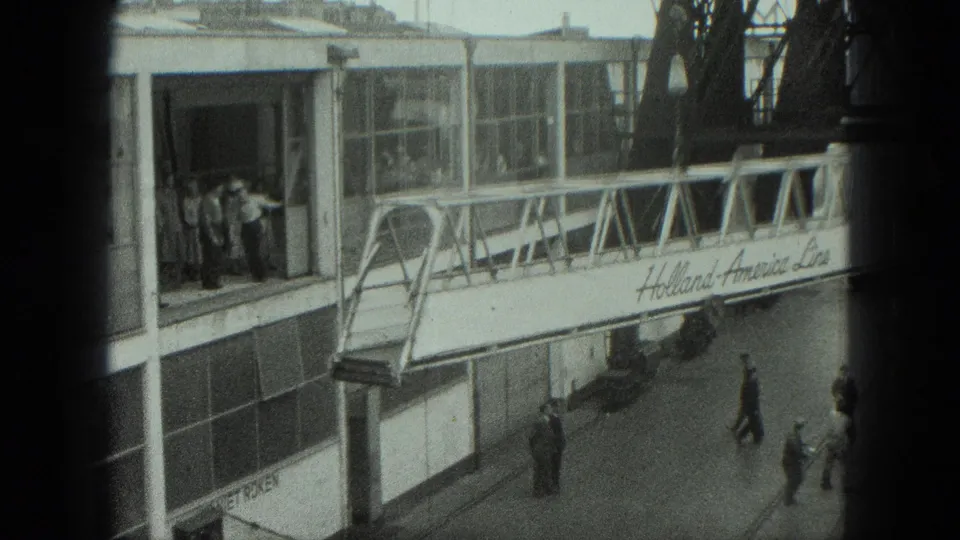 Workers are seen around the terminal doorway and below a Holland-America Line gangway in the 1975 Venice port scene.