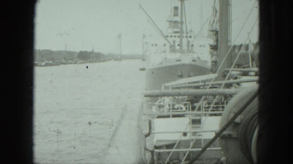 1975 Venice port footage with a large moored vessel, calm water, dock equipment, and handheld 8mm framing.