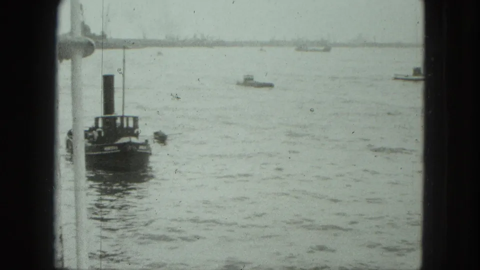 Venice harbor footage shows a dark small vessel beside a white window frame, with other boats faintly visible in the distance.