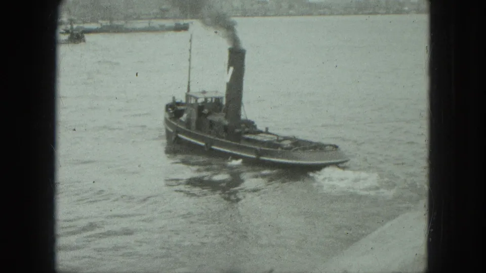 1975 Venice 8mm frame showing the tugboat underway on open water, with smoke from the stack and a pale wake behind it.