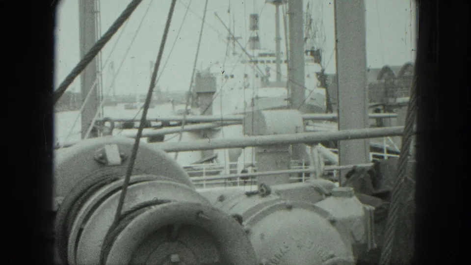 1975 Venice shipboard view of rounded deck machinery, rigging lines, railings, and a larger vessel structure beyond.
