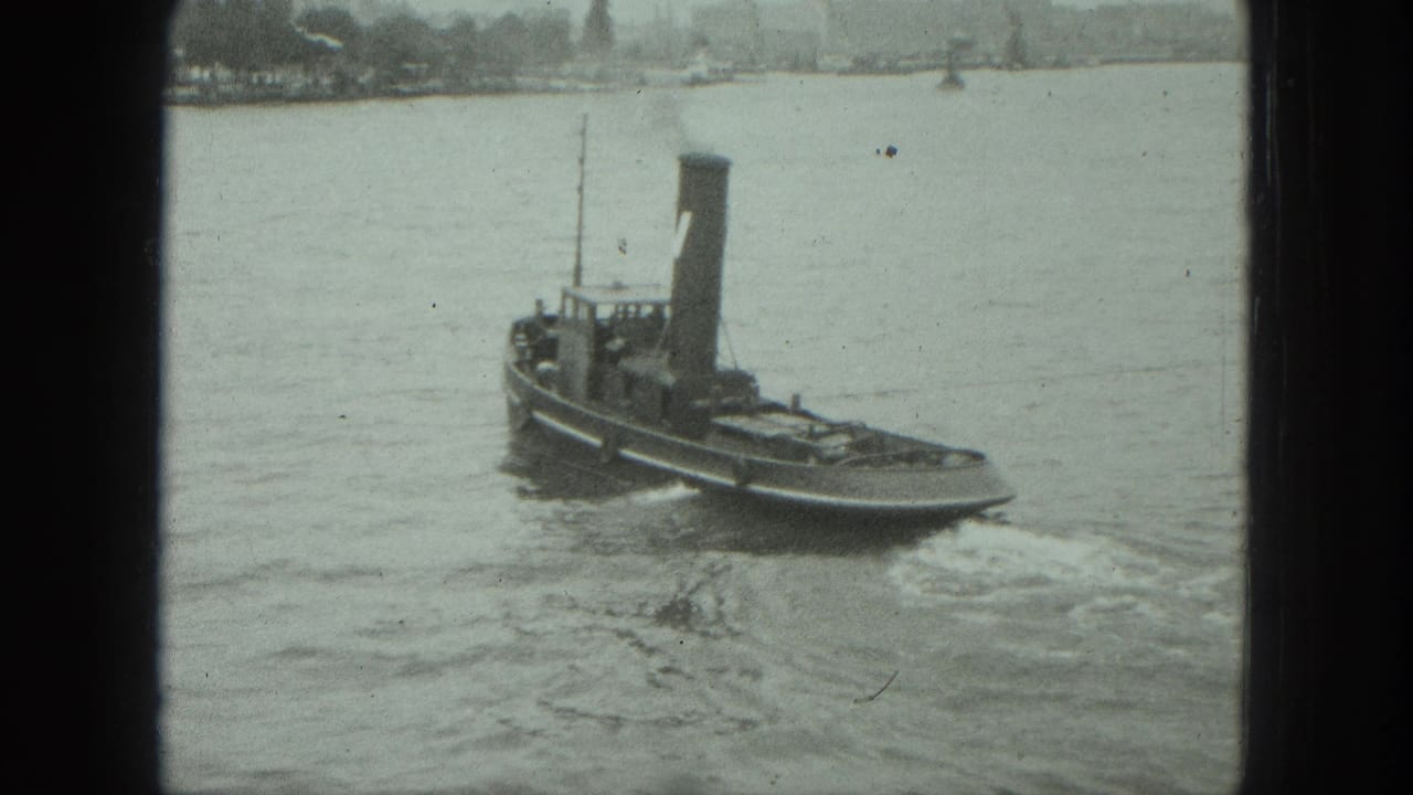 1975 Venice harbor view of a small tugboat with a tall smokestack leaving a wake on calm water.