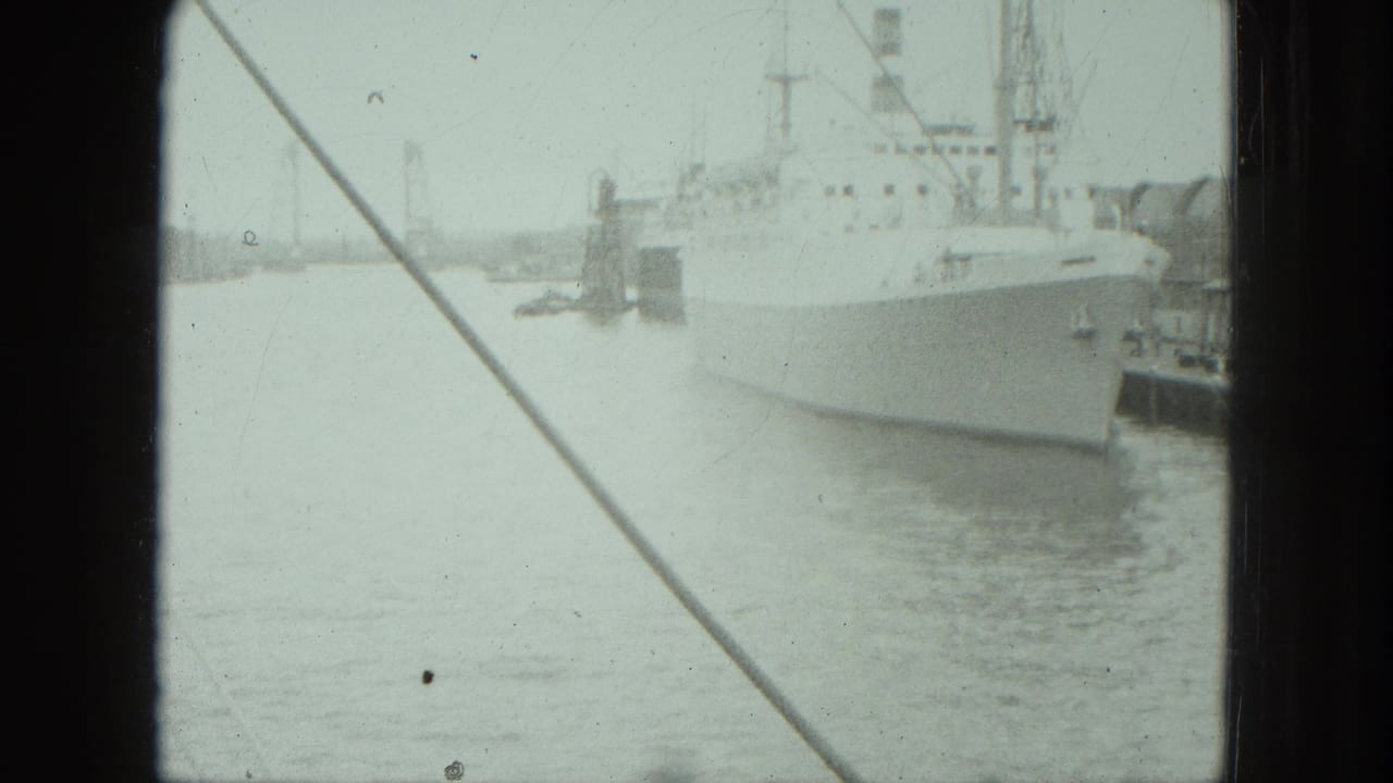 A white vessel remains docked in the Venice harbor while diagonal rigging and dark film borders frame the soft 8mm view.
