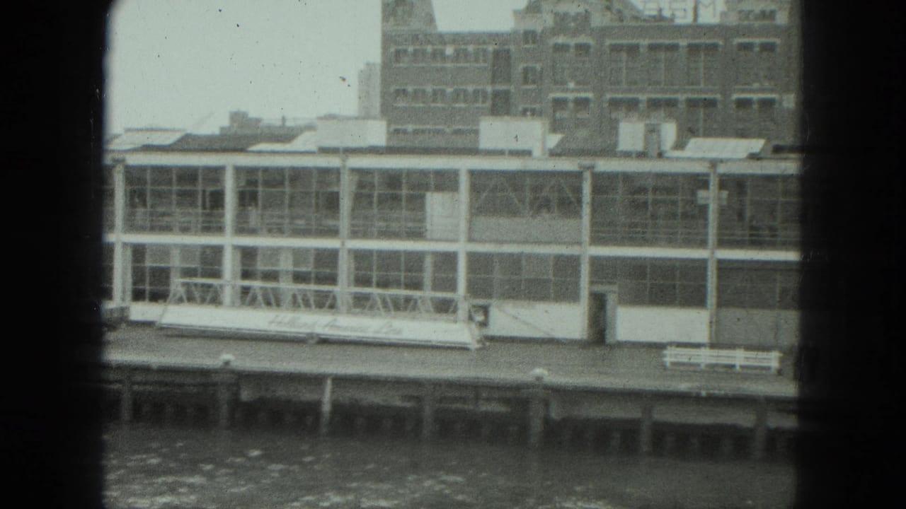 1975 Venice waterfront view of a white glass-fronted pier structure across choppy water, seen through dark framing.