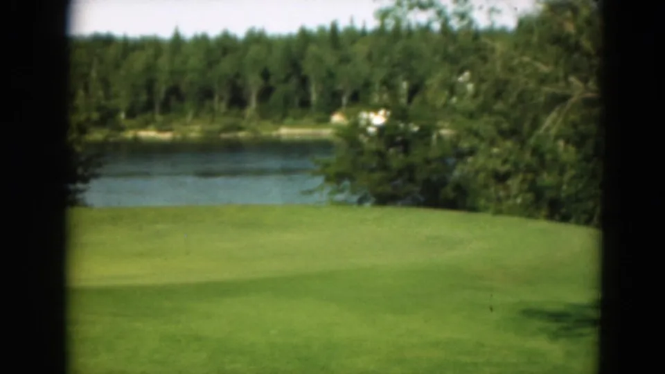 The final frame holds on the golf green, lake, and wooded shoreline in the supported Duluth, Minnesota 1975 clip.