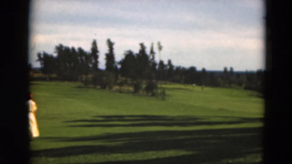 In the final frame, the woman is partly hidden by the dark 8mm frame border as the fairway and tree line remain visible.