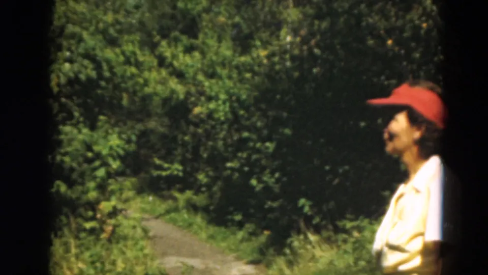 Profile view of a woman in a red cap near a wooded golf-course path in Duluth, Minnesota, 1975.