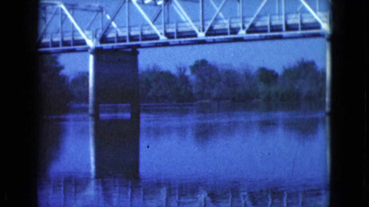 Bridge span over water with trees along the far shoreline.