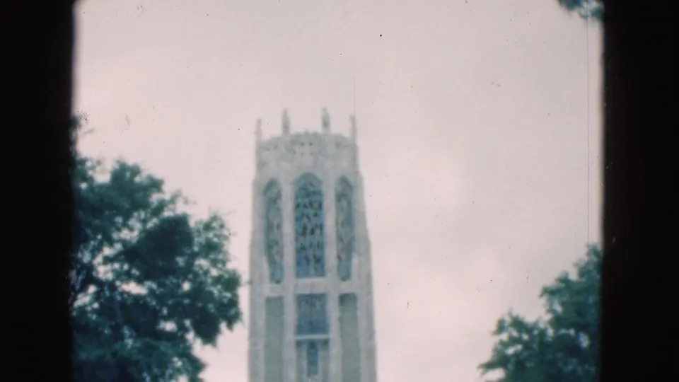 1975 Florida 8mm frame with the tall arched tower centered between trees, showing soft color and home-movie grain.