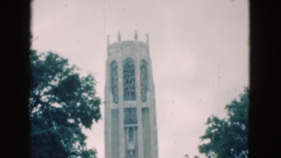 1975 Florida 8mm frame showing the tower's arched panels and surrounding trees near the end of the short shot.