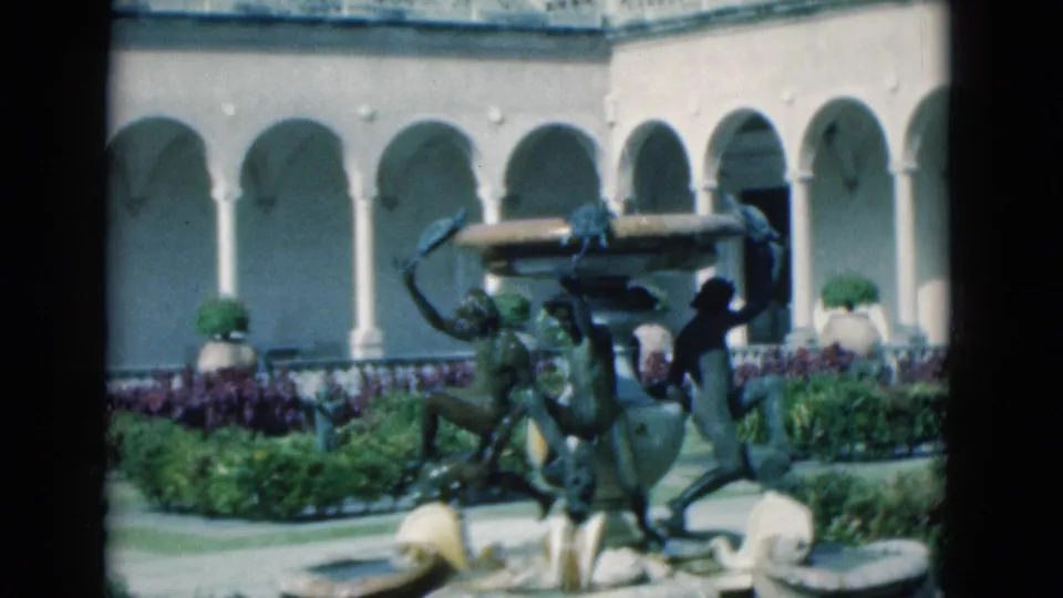 A wider 1975 Florida courtyard view shows the sculptural fountain, stone basins, white arches, lawn, shrubs, and a small figure near the left edge.