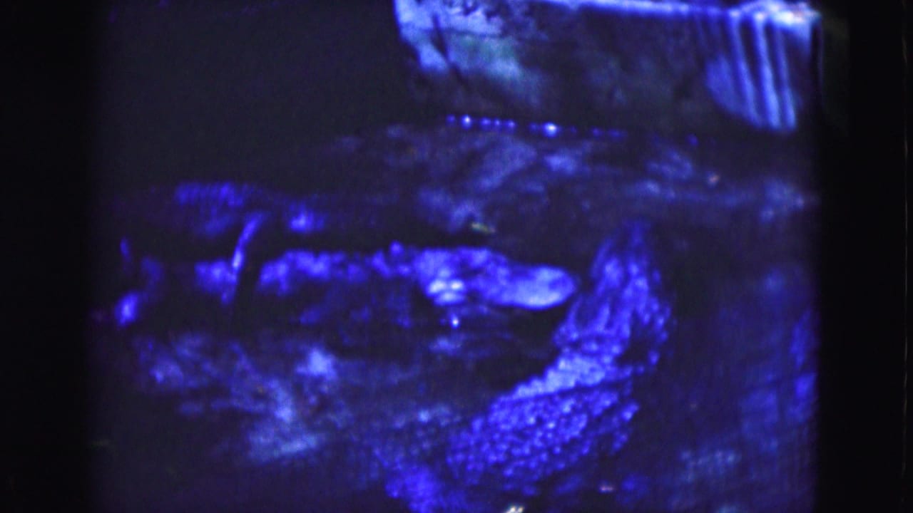 Blue low-light abstract surface with bright curved texture and dark surrounding areas.