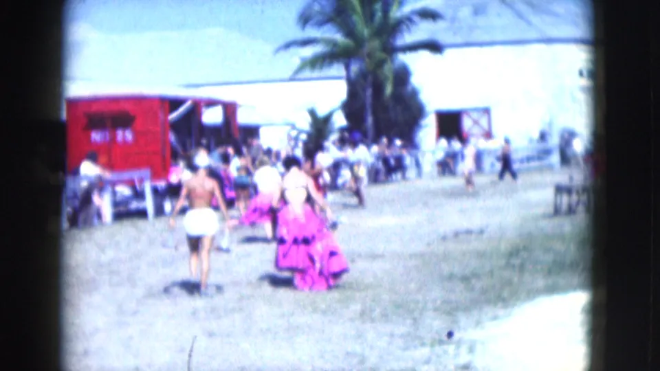 A brief outdoor Florida scene shows people walking near a red structure and palm tree, likely adjacent footage from the same home-movie reel.