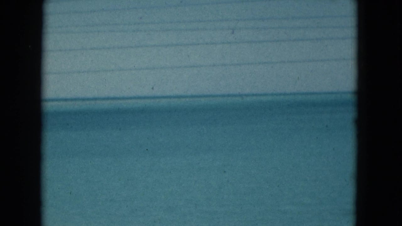 Blue ocean and pale sky seen through dark vertical frame edges and faint horizontal lines.