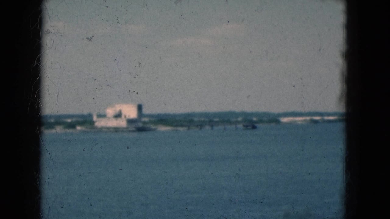 1975 Florida waterfront view with a distant building across the water, softened by 8mm grain and exposure.